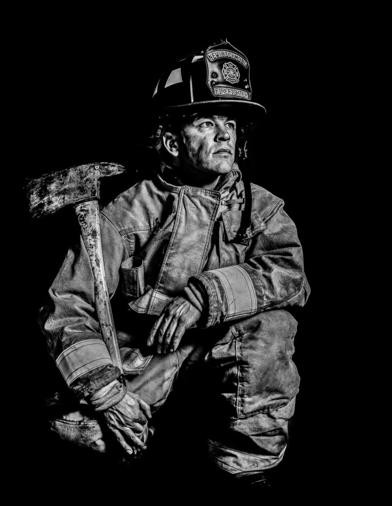Firefighter sqautting down looking up for inspiration in black and white