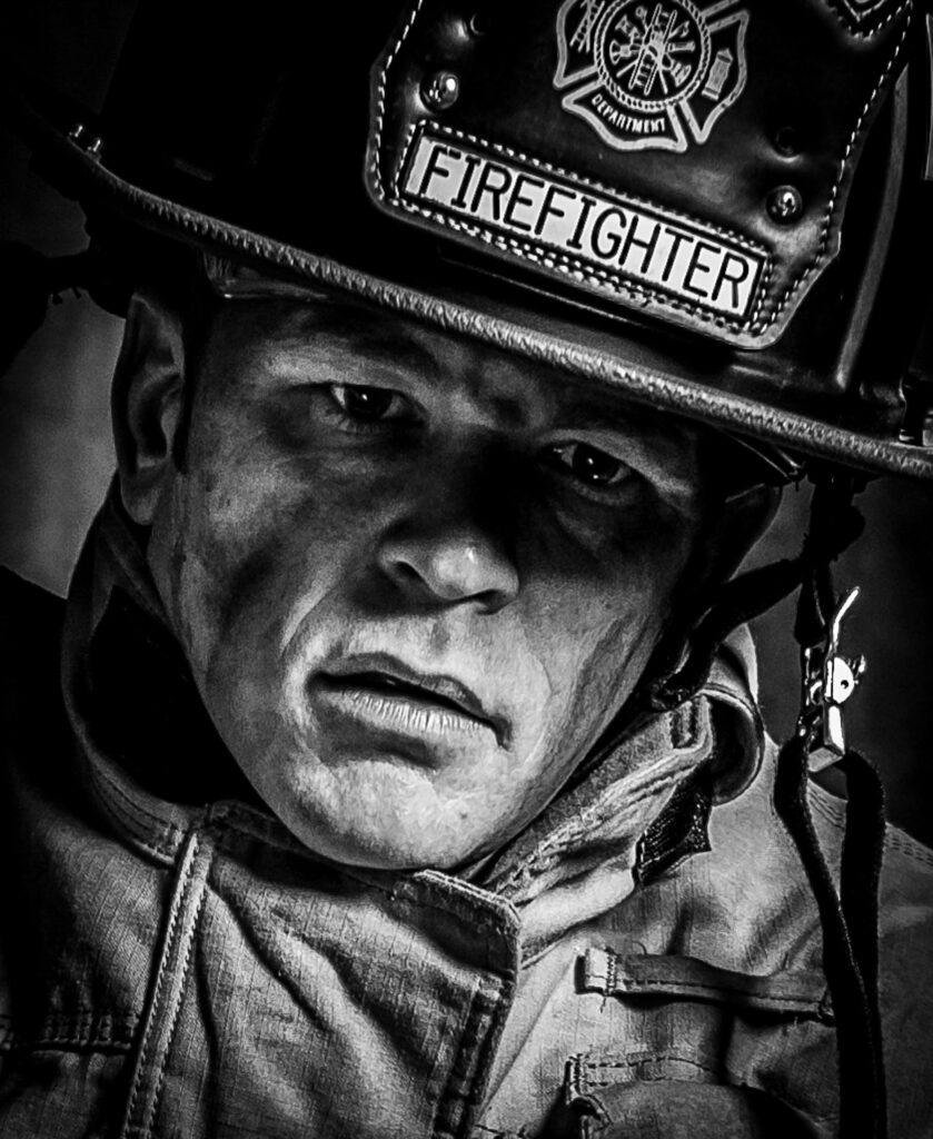Close up of a firefighter in black and white looking with emotion