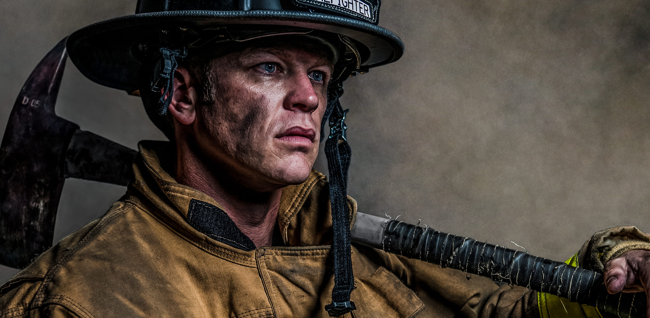 Firefighter portrait zoomed in looking emotional with smoke in the background