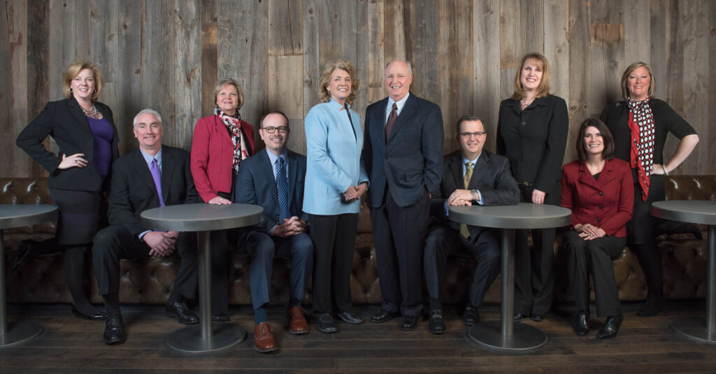 Executive team portrait with ten executives in rustic wood environment, cropped up view