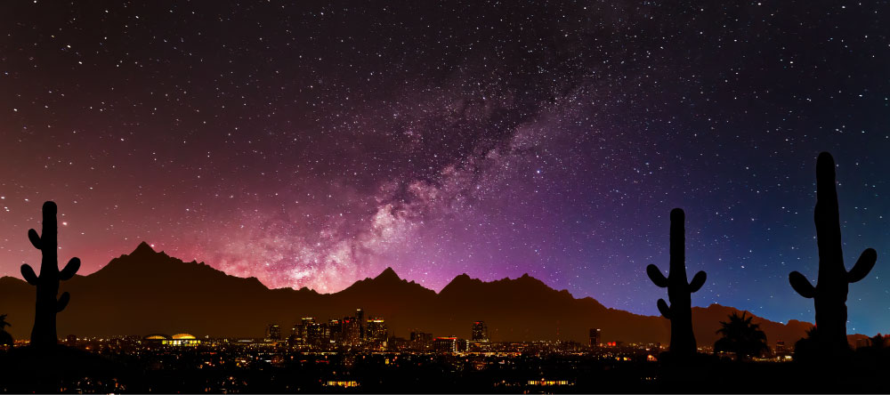 Nighttime cityscape of Phoenix and Scottsdale area with the stars and mountain in the background